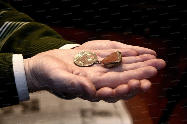 Владимир Иванович Аринин держит медаль отца.jpg